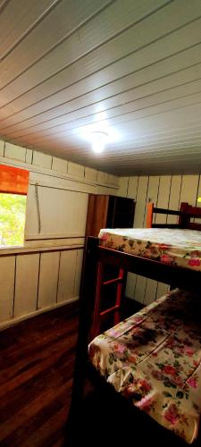 Pokój z 2 łóżkami piętrowymi i oknem w obiekcie Casa de férias e camping w mieście São Félix do Xingu