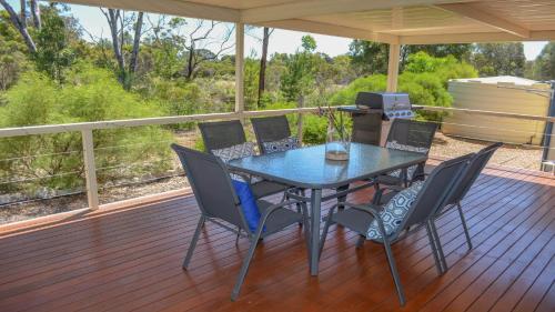 a dining table and chairs on a deck at Lords Retreat in Coffin Bay