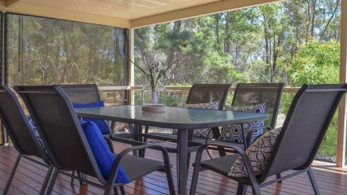 a table and chairs on a screened porch at Lords Retreat in Coffin Bay