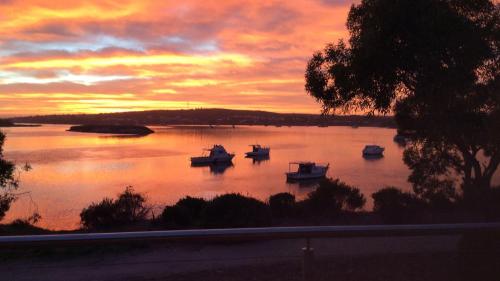 a group of boats in a lake at sunset at Seasalt in Coffin Bay