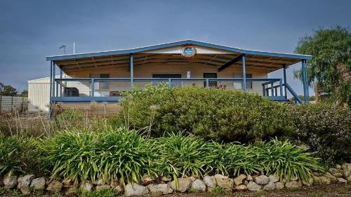 une maison avec un toit bleu et des plantes devant elle dans l'établissement Mariners View Coffin Bay, à Coffin Bay