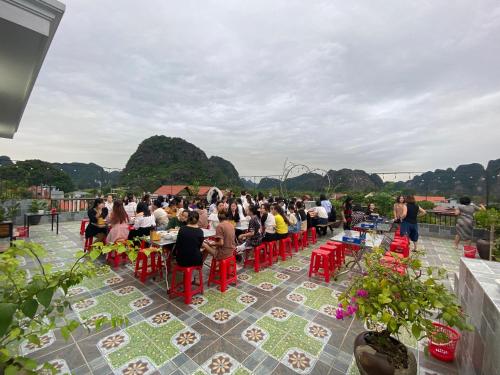 a crowd of people sitting at tables on a roof at Hang Múa Green Mountain View House in Ninh Binh