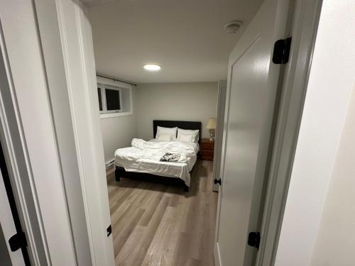 um pequeno quarto com uma cama e um corredor em Luxury Vacation Space em Moncton