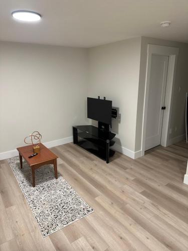 uma sala de estar com uma televisão e uma mesa de centro em Luxury Vacation Space em Moncton