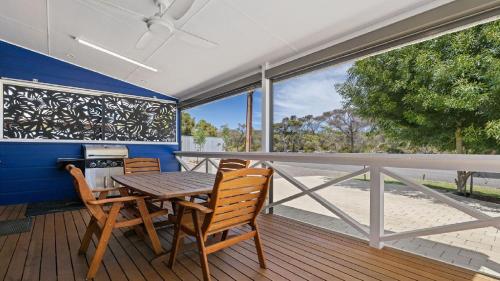 a dining room with a table and chairs on a deck at The Boathouse in Coffin Bay