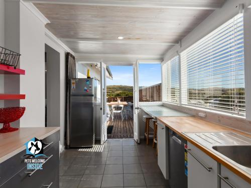 a kitchen with a large window and a refrigerator at Stones Throw to Beach & Chiton Surf Club in Hayborough