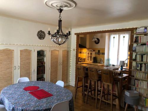 une cuisine avec une table et une cuisine avec une salle à manger dans l'établissement Agréable maison de village avec jardin., à Beaulieu-sur-Dordogne