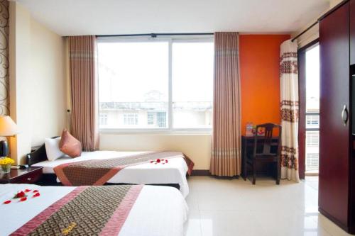 ein Hotelzimmer mit 2 Betten und einem Fenster in der Unterkunft DMZ Hotel in Hue