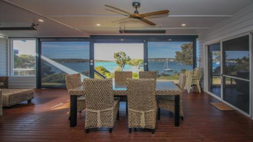 comedor con mesa y sillas y ventilador de techo en Waterfront on Osprey, en Coffin Bay