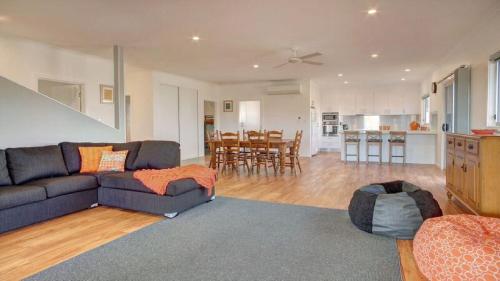 a living room with a couch and a kitchen at Grey On The Bay in Coffin Bay