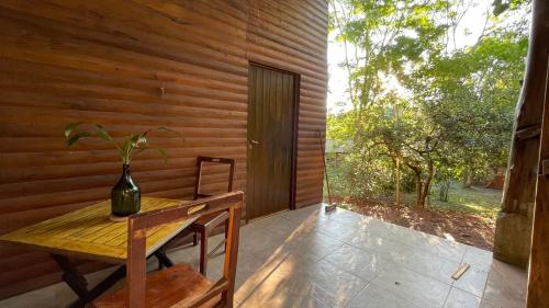 ein Holzraum mit einem Tisch und einer Vase darauf in der Unterkunft Casa Barranca del Mbocay in Puerto Iguazú