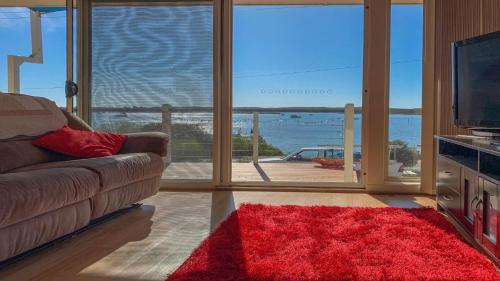 a living room with a couch and a view of the ocean at Seascape in Coffin Bay
