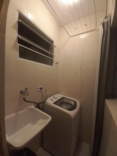 a small bathroom with a toilet and a sink at Suíte Studio 1 Enseada Tortuga Mobiliada in Guarujá