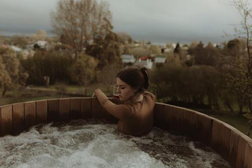 una mujer sentada en una bañera de agua en The Eco Cabin Tasmania, en Deloraine