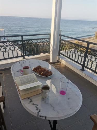 KoutsourásにあるStratos Sunset Houseのバルコニーにテーブルと食べ物を用意しています。