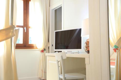a room with a desk with a computer and a window at Inghirios Wellness Country Resort in Santa Maria la Palma