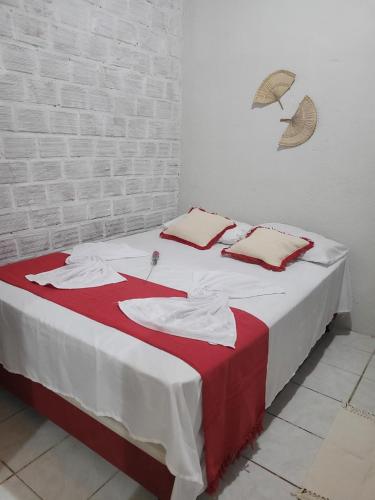 Cama con sábanas y almohadas rojas y blancas en República Francês, en Marechal Deodoro