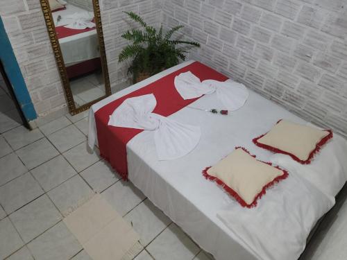a red and white bed in a room with a mirror at República Francês in Marechal Deodoro