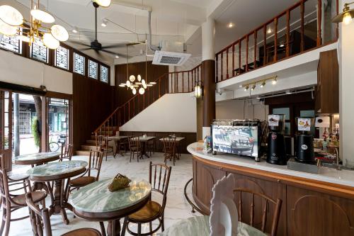 a restaurant with tables and chairs and a bar at Loftel 22 Hostel in Bangkok