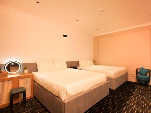 a bedroom with two beds and a desk with a mirror at Phước Hưng 3 Hotel in Vĩnh Long