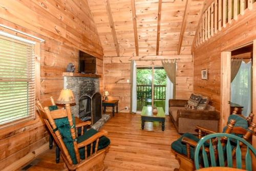 a living room with a fireplace in a log cabin at Creekside cabin in Townsend