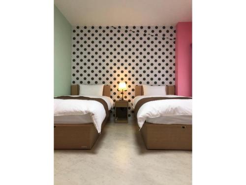 川口市にあるWALLABY HOUSE - Vacation STAY 38651vのベッドルーム1室(ベッド2台付)、壁に水玉が付いています。