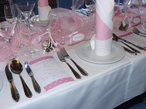 a table with a white table cloth with silverware at AGH Hotel in Rožnov pod Radhoštěm