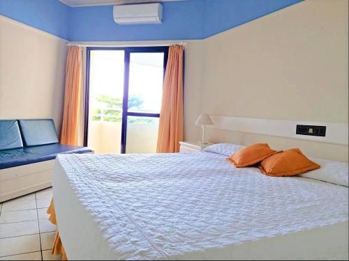 um quarto com uma cama grande e uma janela em Pé na Areia em Floripa em Florianópolis