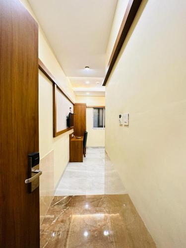 a hallway with a door and a room with a desk at HOTEL BKC DOWNTOWN - NEAR US EMBASSY in Mumbai
