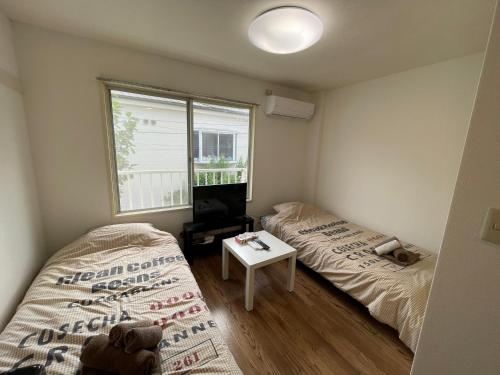 Habitación con 2 camas, TV y ventana. en Tokyo Stay Dolce, en Tokio