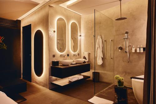 a bathroom with two sinks and a shower with mirrors at Je Ne Sais Quoi Seminyak in Seminyak