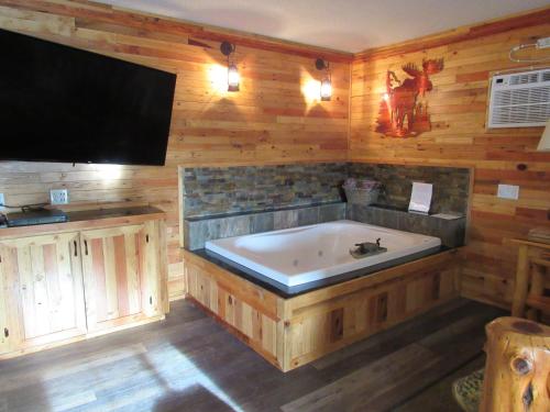 a large bath tub in a room with a tv at The Woodsman Country Lodge Motel in Crescent