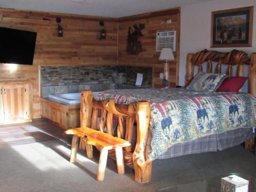 a bedroom with a large bed and a fireplace at The Woodsman Country Lodge Motel in Crescent