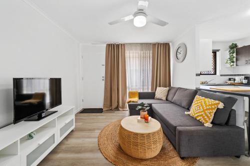a living room with a couch and a tv at Mount Warren Park Stay 2 BR for Work and Families in Windaroo