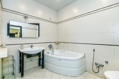 La salle de bains blanche est pourvue d'une baignoire et d'un lavabo. dans l'établissement SAHIL PARK 2 Bedrooms, à Baku