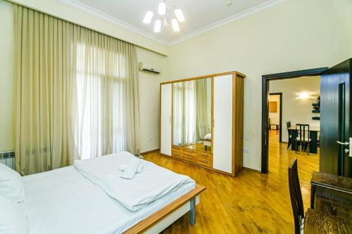 - une chambre avec un lit blanc et un miroir dans l'établissement SAHIL PARK 2 Bedrooms, à Baku