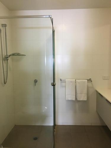 a bathroom with a glass shower stall with towels at Best Western Plus The Tudor Box Hill in Box Hill