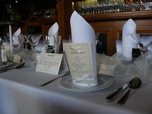 a table with a white table cloth with wine glasses at AGH Hotel in Rožnov pod Radhoštěm