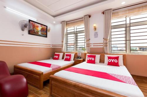 2 bedden in een kamer met rode en witte kussens bij Sao Mai - 16A Võ Thị Phải, Quận12 - by Bay Luxury Hotel in Ho Chi Minh-stad