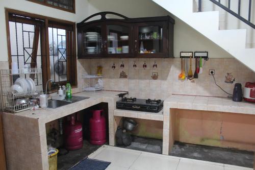 uma cozinha com um lavatório e um fogão em Homestay Bougenville Antapani Syariah em Bandung