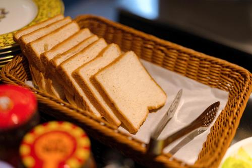 a basket with slices of bread and a fork and knife at Beijing Xin xiang YaYuan Countyard Hotel&NearWang Fu Jing Forbidden City Lama Temple and Summer palace,5 minutes walk from subway ,Free Laundry and coffee in Beijing