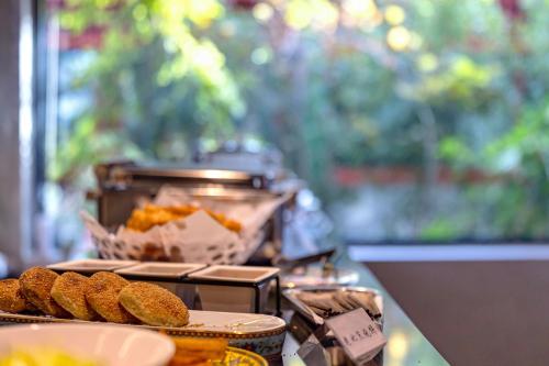 a table with a plate of food on a counter at Beijing Xin xiang YaYuan Countyard Hotel&NearWang Fu Jing Forbidden City Lama Temple and Summer palace,5 minutes walk from subway ,Free Laundry and coffee in Beijing