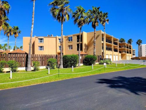 an empty street in front of a building with palm trees at Surfside I 310 Condominium Condo in South Padre Island