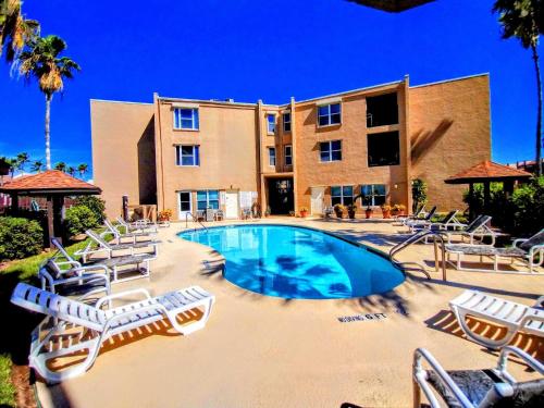 uma piscina com espreguiçadeiras e um edifício em Surfside I 310 Condominium Condo em South Padre Island