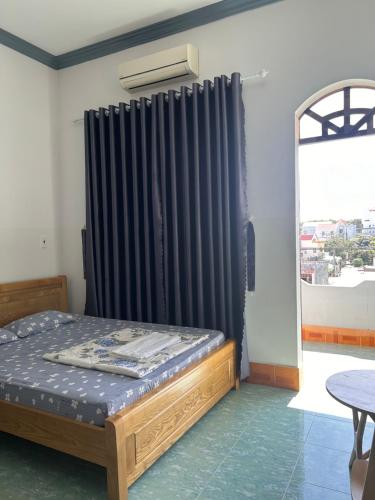 1 dormitorio con 1 cama con cortina negra en Hotel Minh Vy, en Long Hai