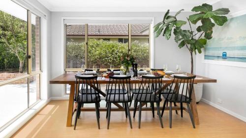 a dining room with a wooden table and chairs at Highlands on Alice in Bowral