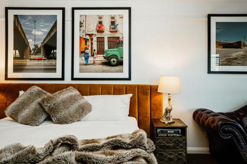 a bedroom with a bed with four pictures on the wall at Daylesford Art Motel in Daylesford