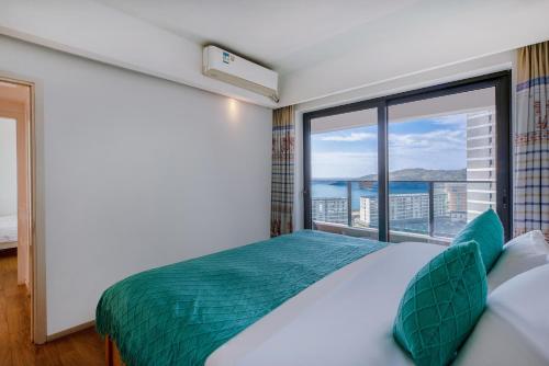 Postel nebo postele na pokoji v ubytování Xiaojing Bay Haige Hotel