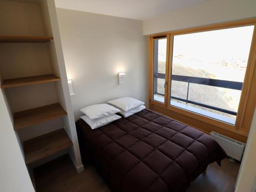 a small bedroom with a bed and a window at Appartement lumineux skis aux pieds avec balcon - FR-1-502-541 in Tignes
