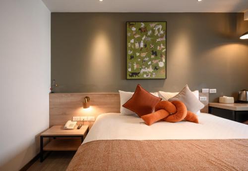 a bedroom with a bed with a teddy bear on it at Hotel East Taichung in Taichung
